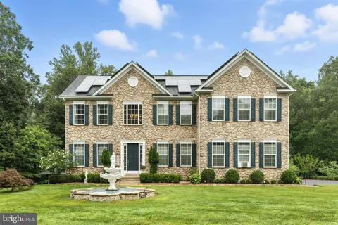 a view of a house with a big yard and large trees