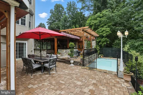 a view of a patio with a table and chairs and a barbeque