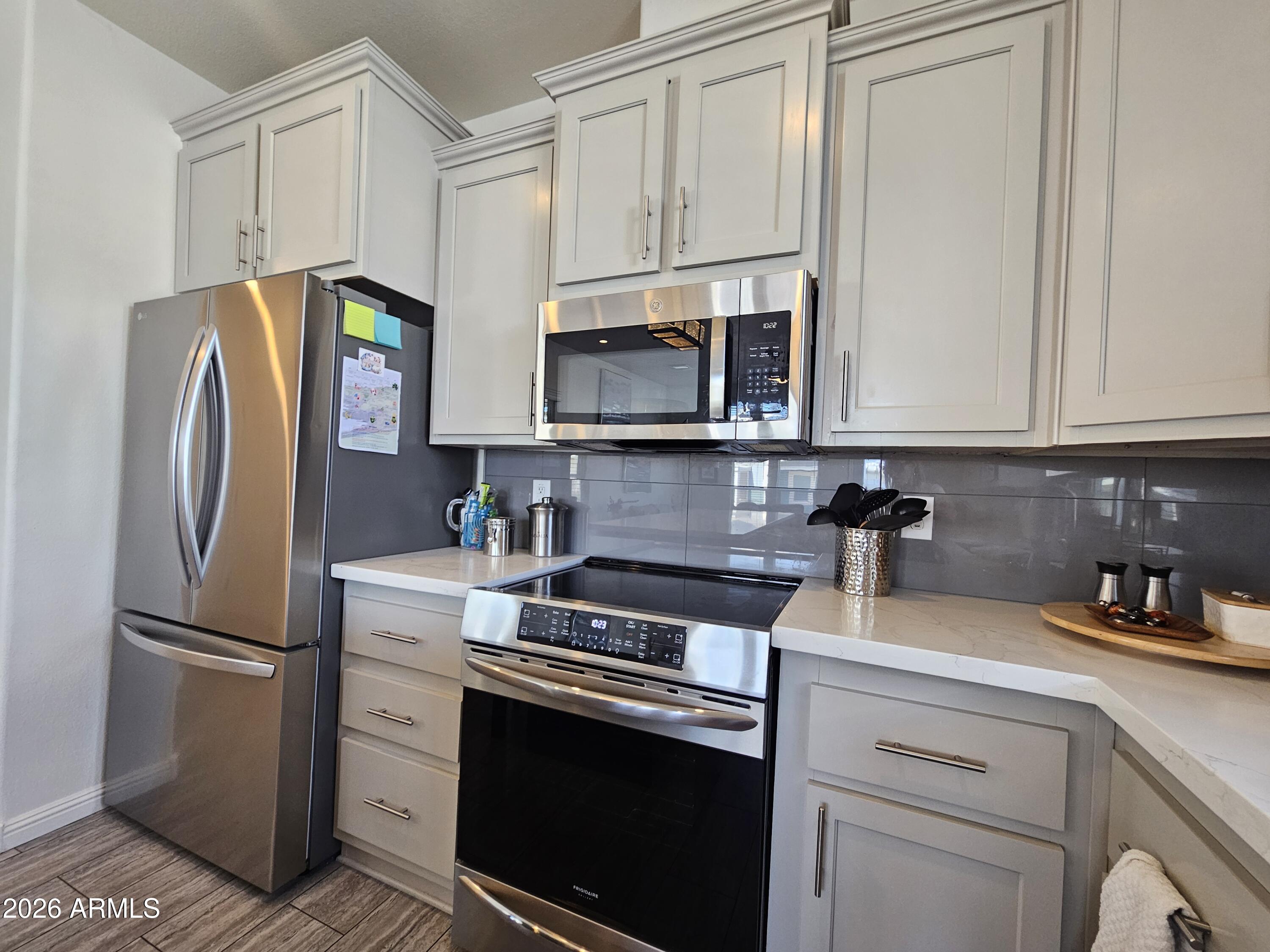 650 North Hawes Road, Unit 3331 Mesa, AZ 85207 - Photo 11 of 38 a kitchen with refrigerator a microwave a stove and cabinets