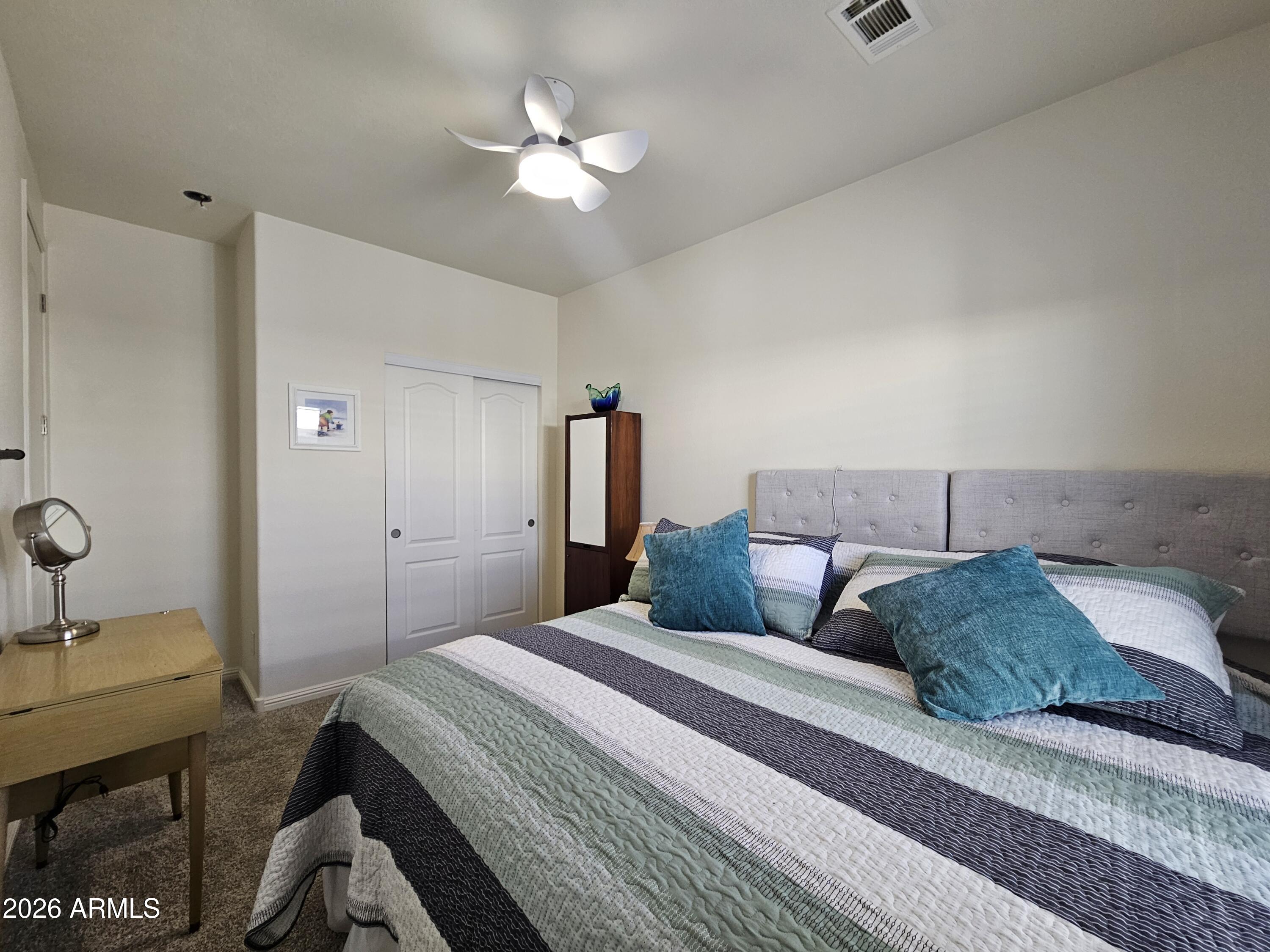 650 North Hawes Road, Unit 3331 Mesa, AZ 85207 - Photo 16 of 38 a bedroom with a bed a chandelier and a dresser