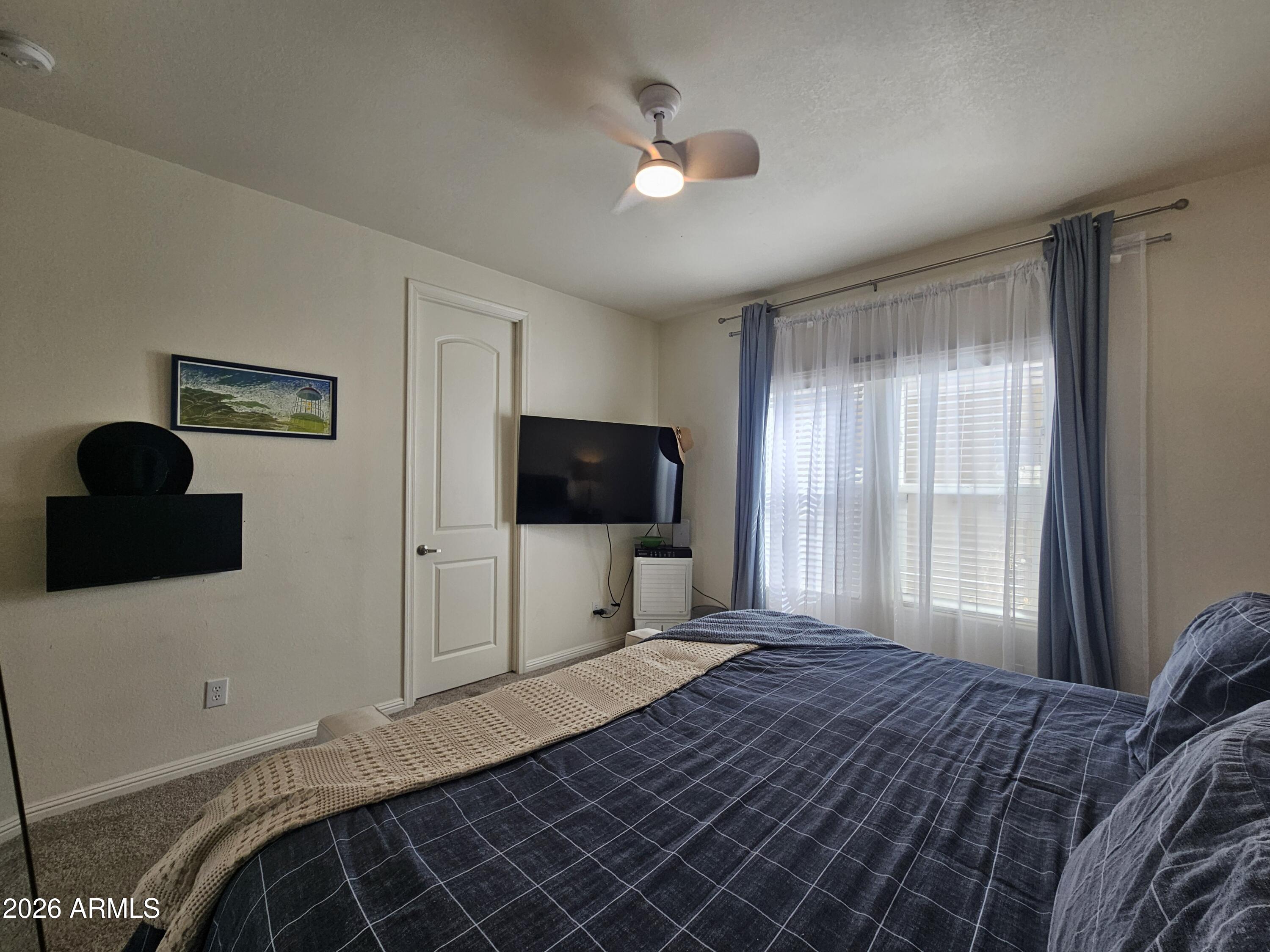 650 North Hawes Road, Unit 3331 Mesa, AZ 85207 - Photo 18 of 38 a bedroom with a bed and a flat screen tv