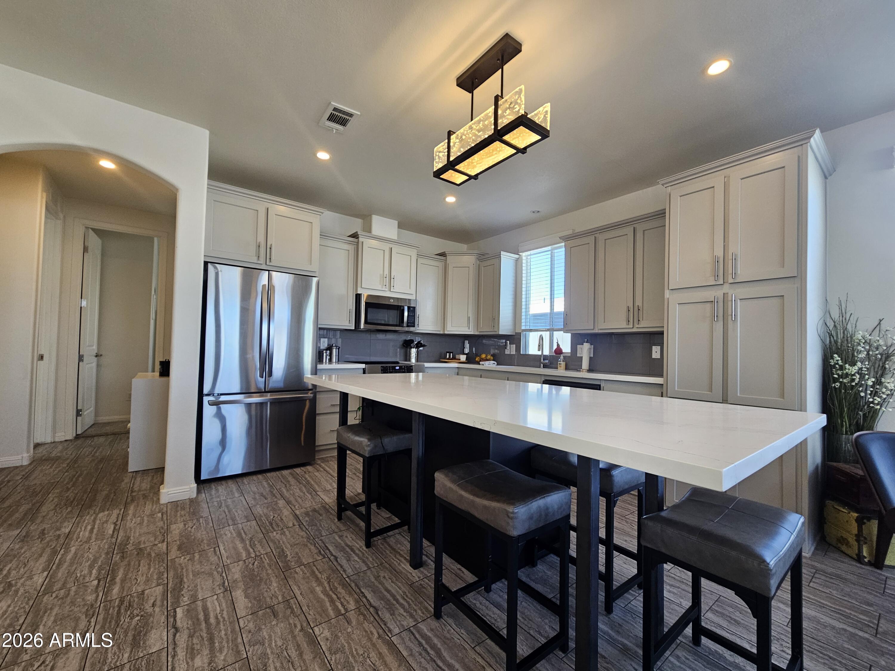 650 North Hawes Road, Unit 3331 Mesa, AZ 85207 - Photo 3 of 38 a kitchen with stainless steel appliances a dining table chairs and refrigerator