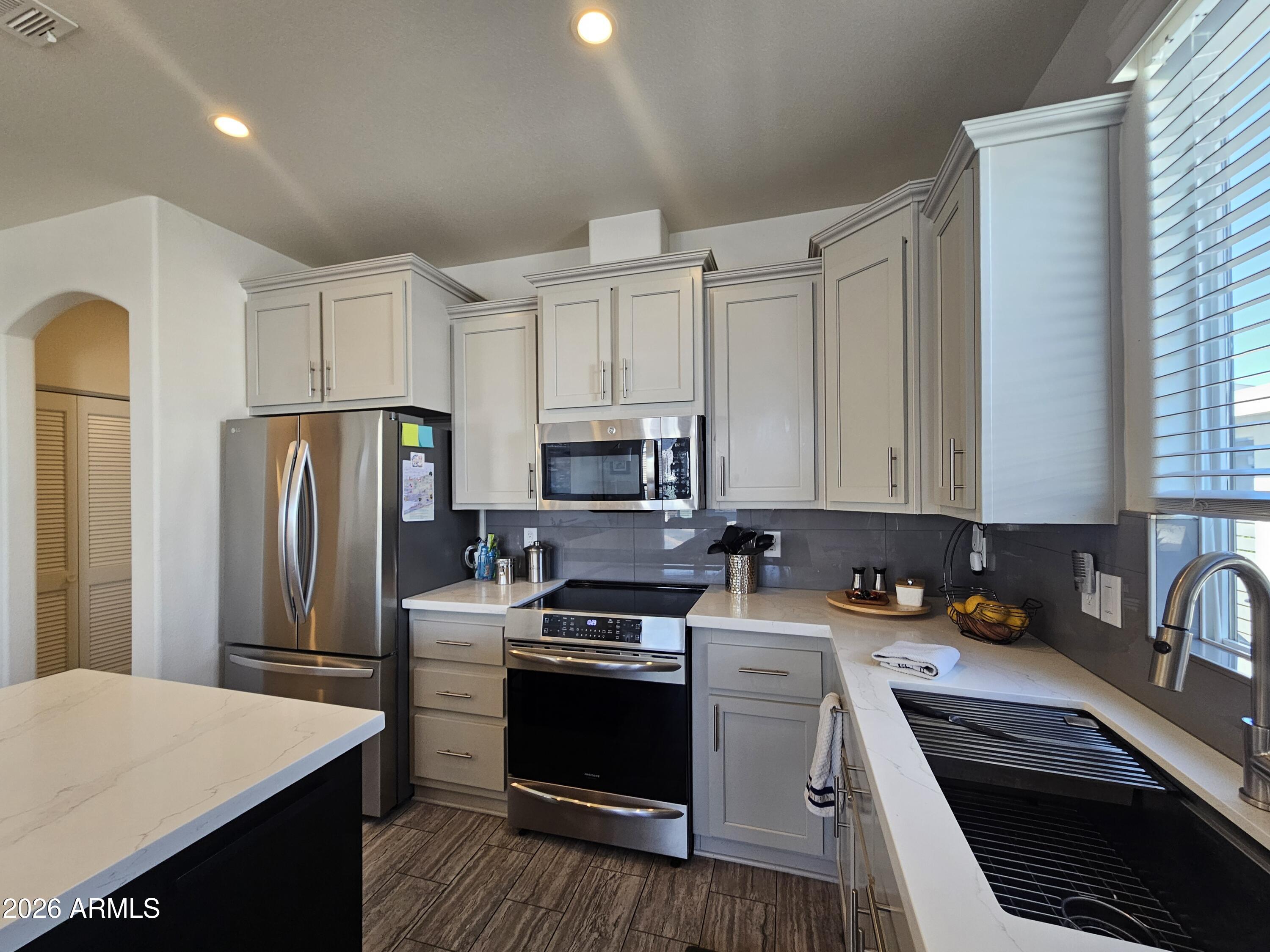 650 North Hawes Road, Unit 3331 Mesa, AZ 85207 - Photo 10 of 38 a kitchen with stainless steel appliances a refrigerator stove sink and cabinets