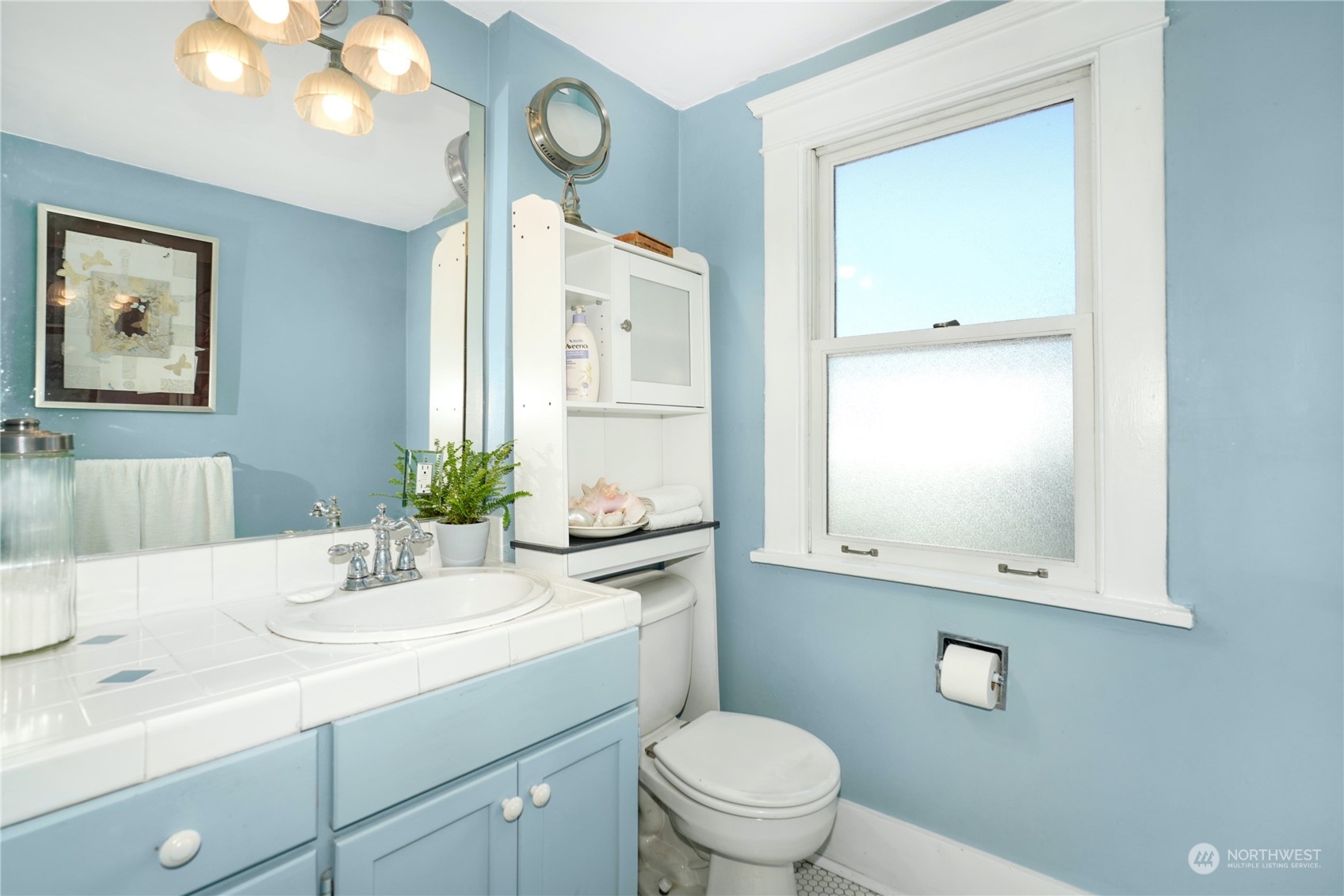 309 North 73rd Street Seattle, WA 98103 - Photo 15 of 30 a bathroom with a toilet a sink and mirror