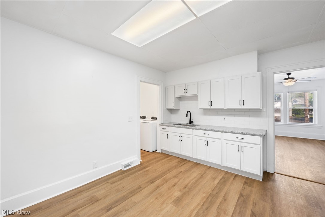 2140 Broadview Road Cleveland, OH 44109 - Photo 8 of 42 Kitchen with backsplash, white cabinetry, light wood-type flooring, and sink