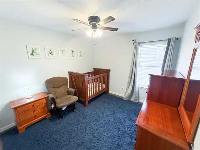 a living room with furniture and a ceiling fan