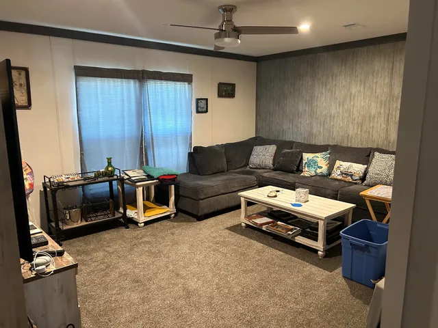 a living room with furniture a flat screen tv and gym equipment