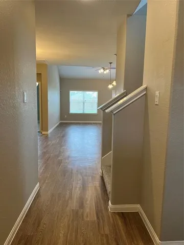 a view of a livingroom with wooden floor and a large window