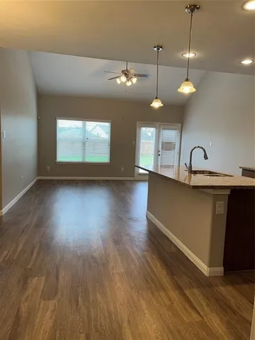 wooden floor in an empty room with a chandelier fan