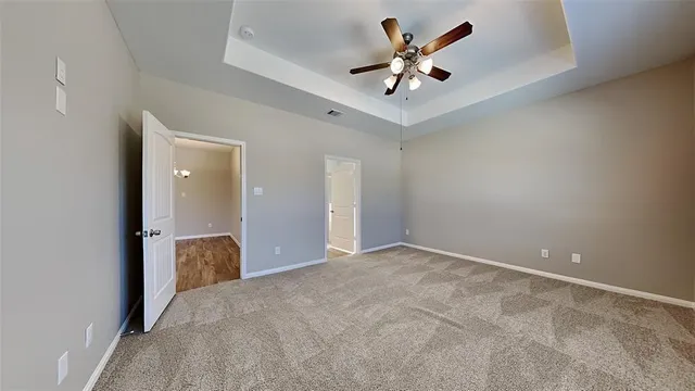 wooden floor in an empty room with a chandelier fan