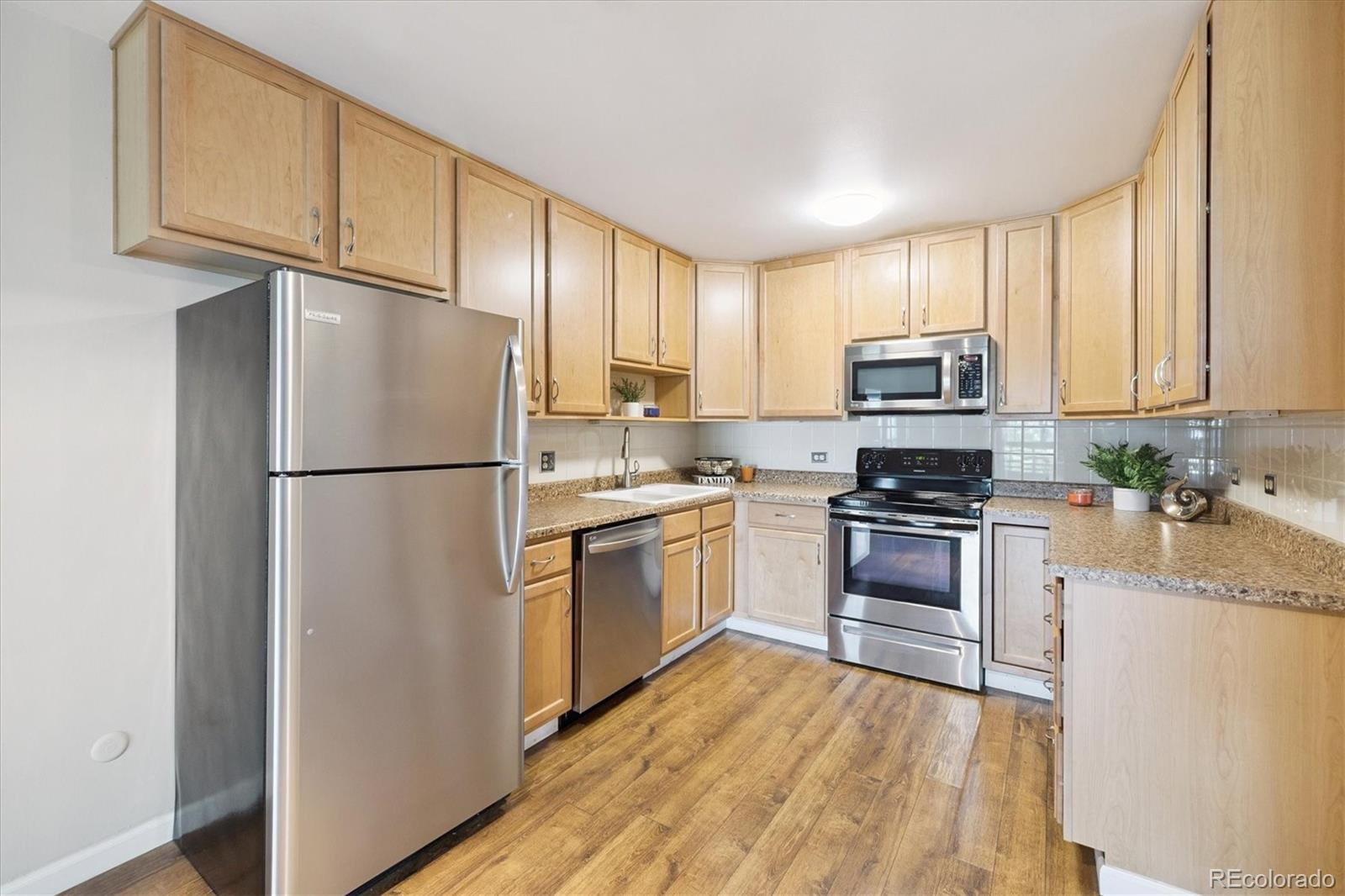 9155 Center Avenue, Unit 2D Denver, CO 80247 - Photo 3 of 50 a kitchen with cabinets stainless steel appliances and a window