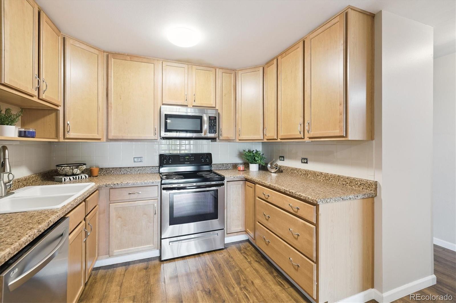 9155 Center Avenue, Unit 2D Denver, CO 80247 - Photo 5 of 50 a kitchen with stainless steel appliances granite countertop a stove a sink and a microwave