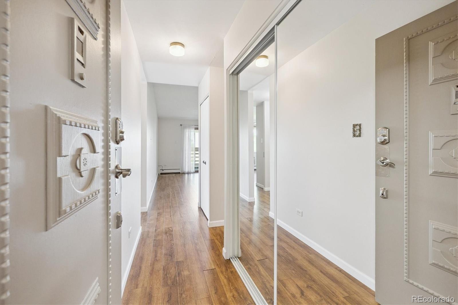 9155 Center Avenue, Unit 2D Denver, CO 80247 - Photo 6 of 50 a view of a hallway with wooden floor and staircase