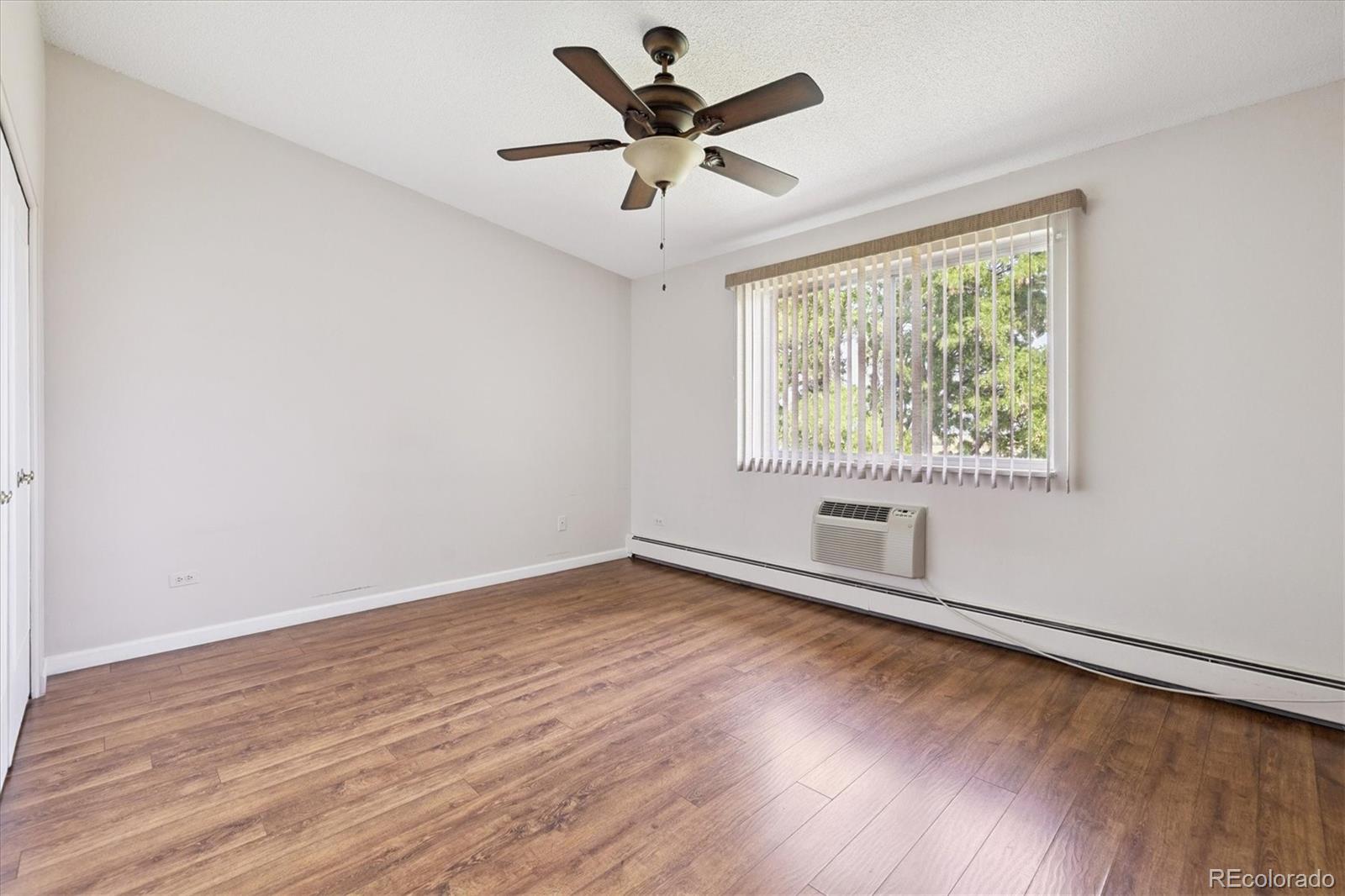 9155 Center Avenue, Unit 2D Denver, CO 80247 - Photo 10 of 50 an empty room with wooden floor and windows