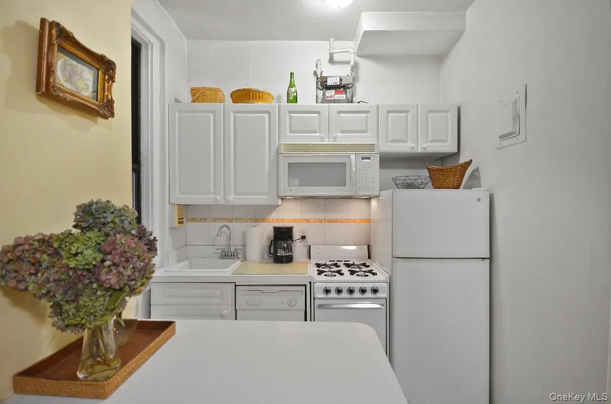17 West 64th Street, Unit 1D Manhattan, NY 10023 - Photo 5 of 7 a kitchen with stainless steel appliances granite countertop a refrigerator and a stove top oven