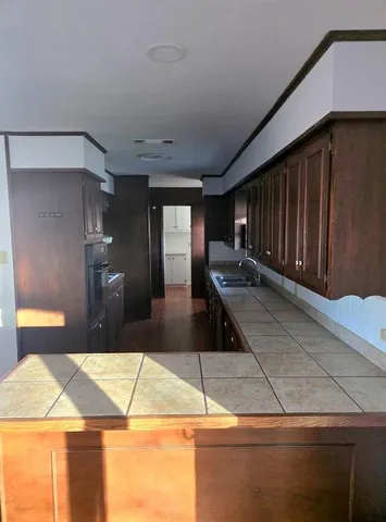 a kitchen with wooden cabinets and a stove top oven