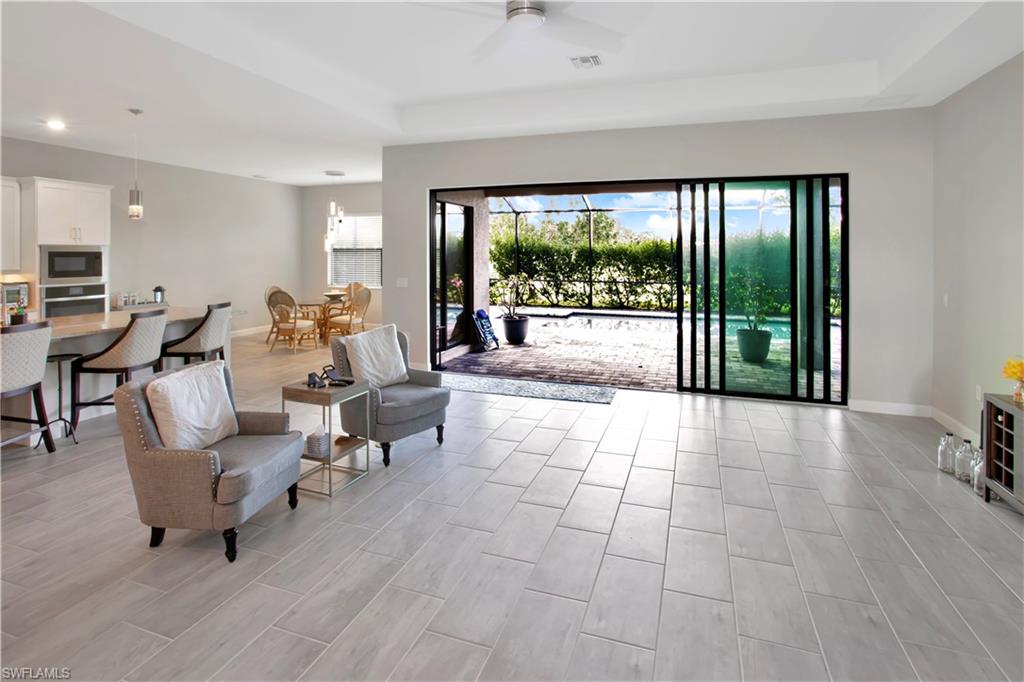 Living area with healthy amount of natural light, wood tiled floors, and ceiling fan