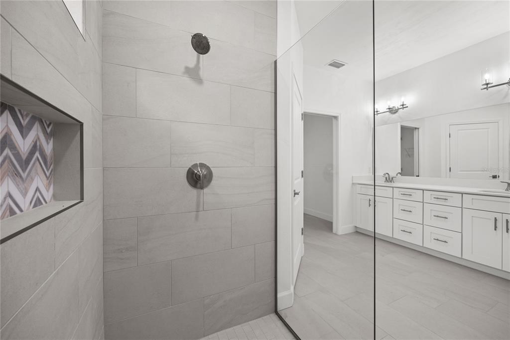1086 Southwest 67th Drive Gainesville, FL 32607 - Photo 13 of 37 a bathroom with a double vanity sink a mirror a shower and vanity