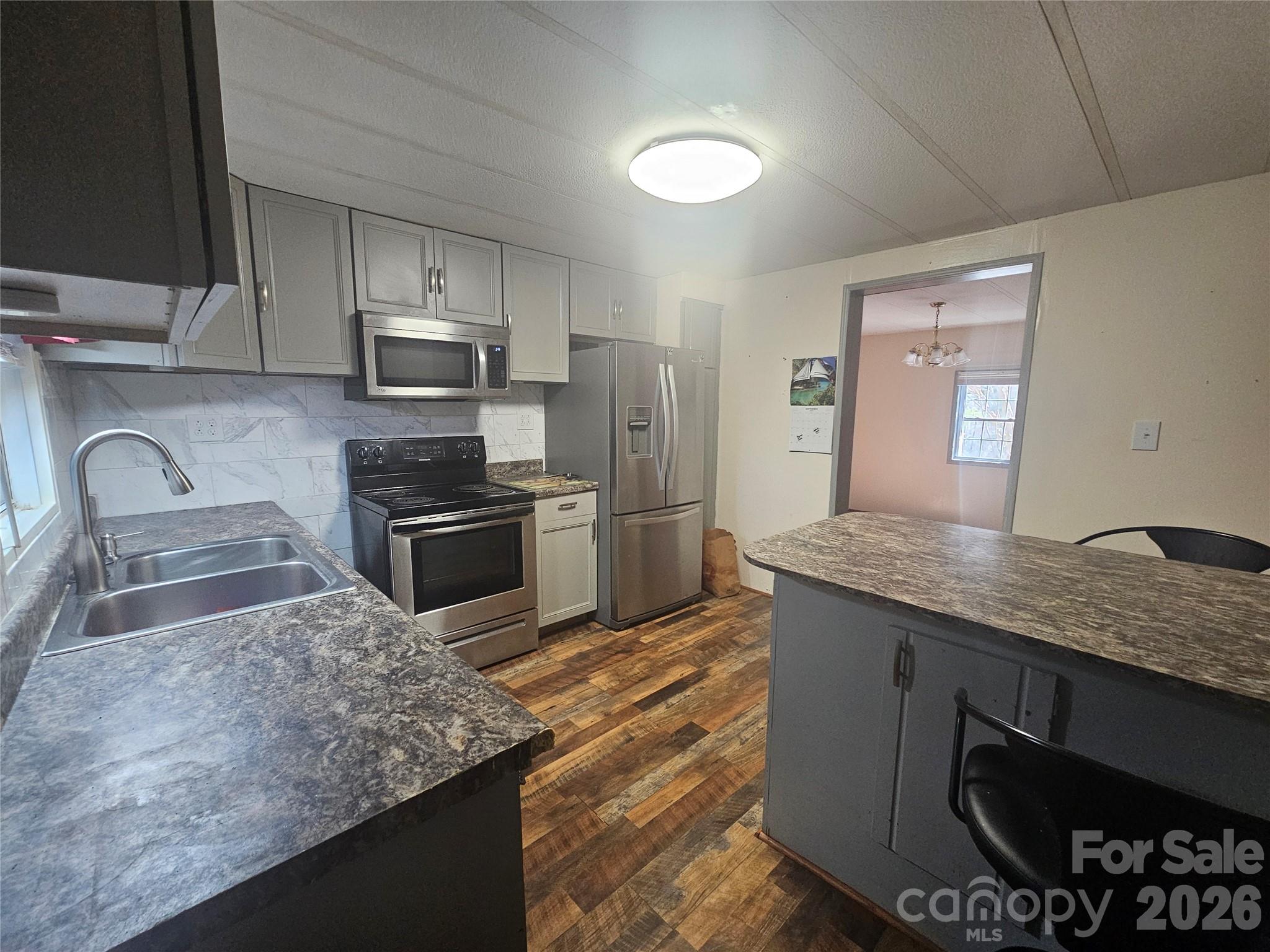 130 Susan Road Casar, NC 28020 - Photo 4 of 14 a kitchen with kitchen island granite countertop a sink stove and refrigerator