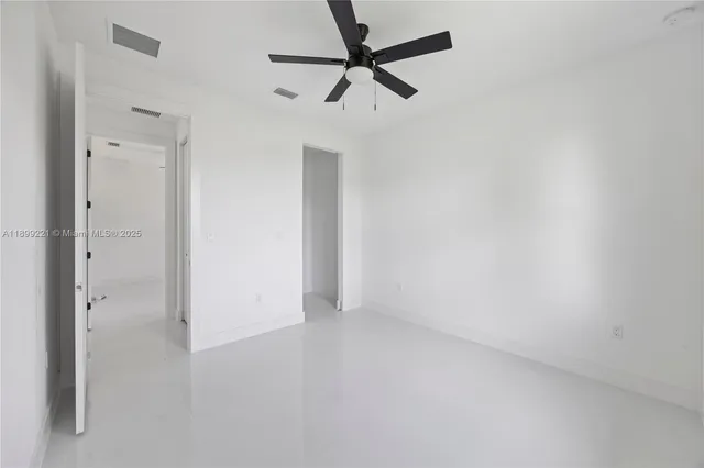 an empty room with a window and a fan