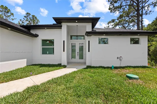a view of a house with a big yard and large tree