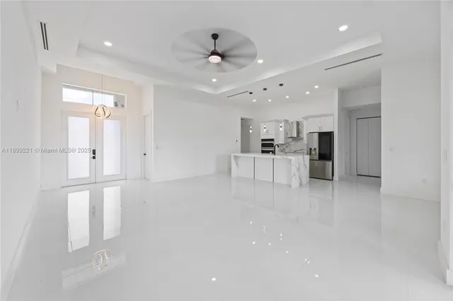 an empty room with windows and fan