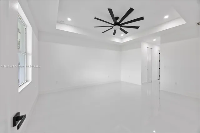 an empty room with windows and fan