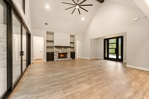 an empty room with windows and ceiling fan