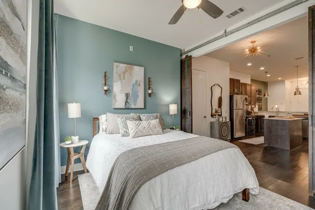 a spacious bedroom with a bed and a chandelier