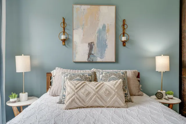 a bed sitting in a bedroom next to a lamp