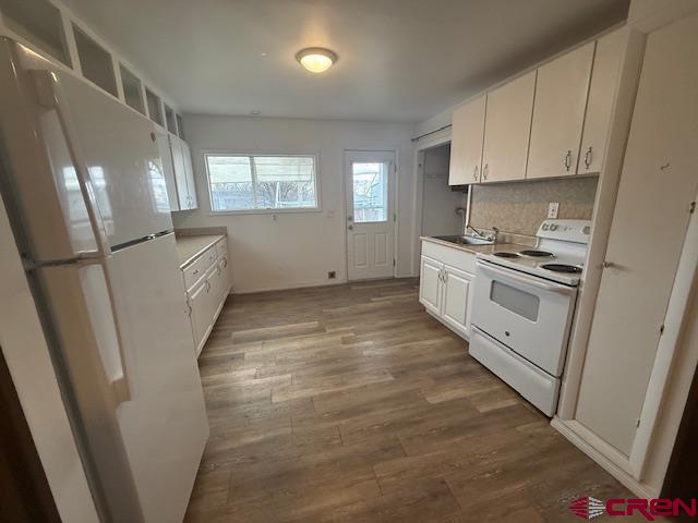 320 Southwest 8th Avenue Cedaredge, CO 81413 - Photo 8 of 18 a kitchen with white cabinets and white appliances
