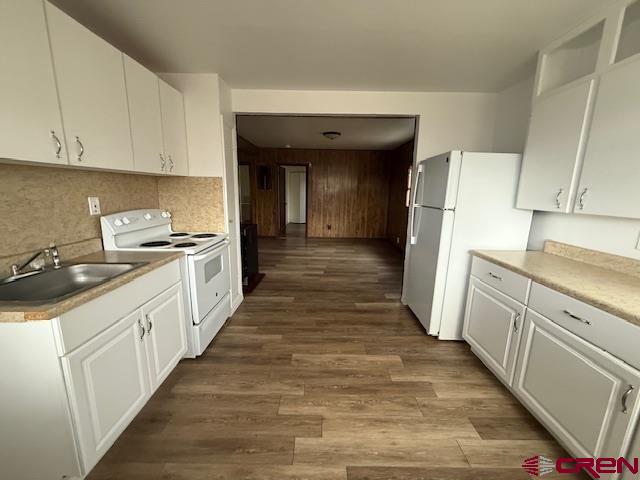320 Southwest 8th Avenue Cedaredge, CO 81413 - Photo 9 of 18 a kitchen with sink a refrigerator and white cabinets