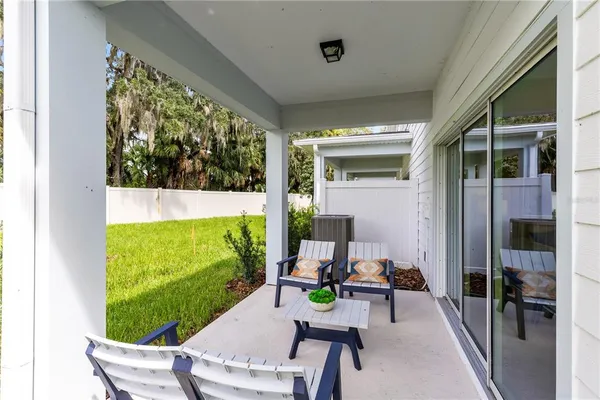 a view of a chair and table in patio with wooden fence