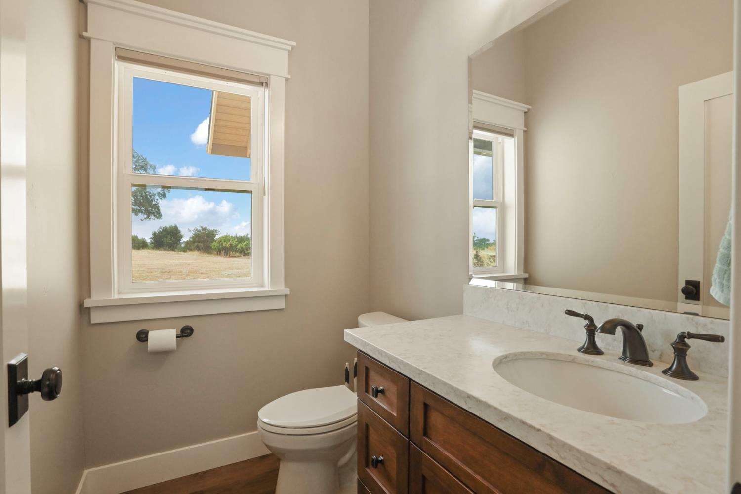 18739 Clements Road Lodi, CA 95240 - Photo 13 of 39 a bathroom with a granite countertop toilet a sink and mirror