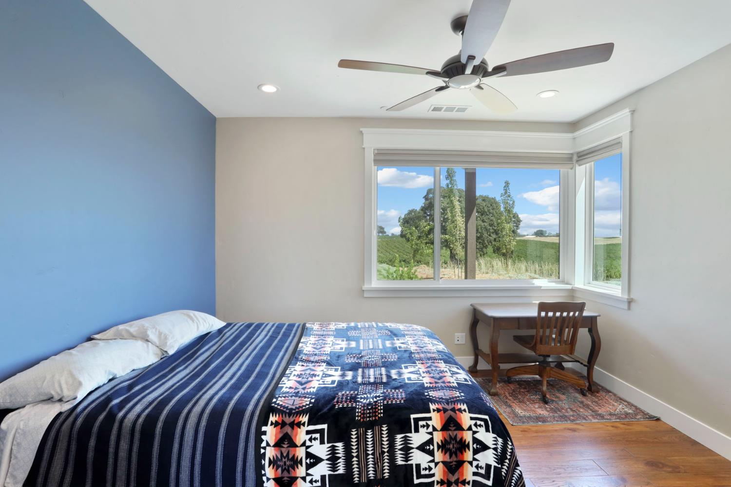 18739 Clements Road Lodi, CA 95240 - Photo 18 of 39 a bedroom with a bed a table and a chandelier