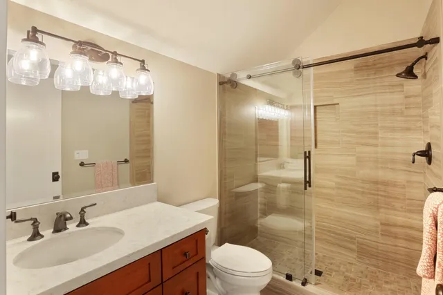 a bathroom with a sink a toilet a mirror and shower curtain