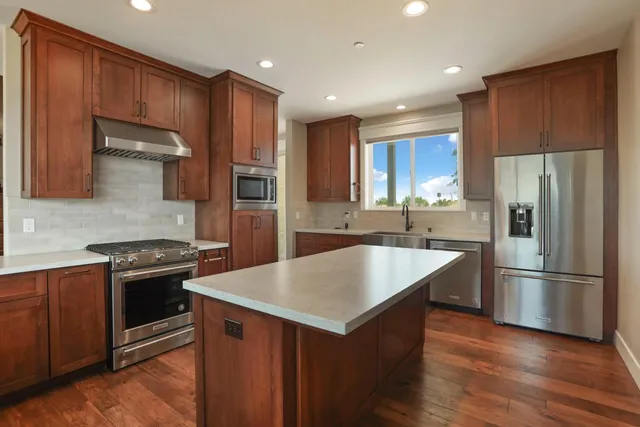 a kitchen with wooden cabinets and stainless steel appliances