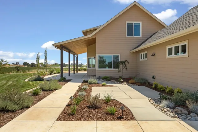 a view of a house with backyard sitting area and garden