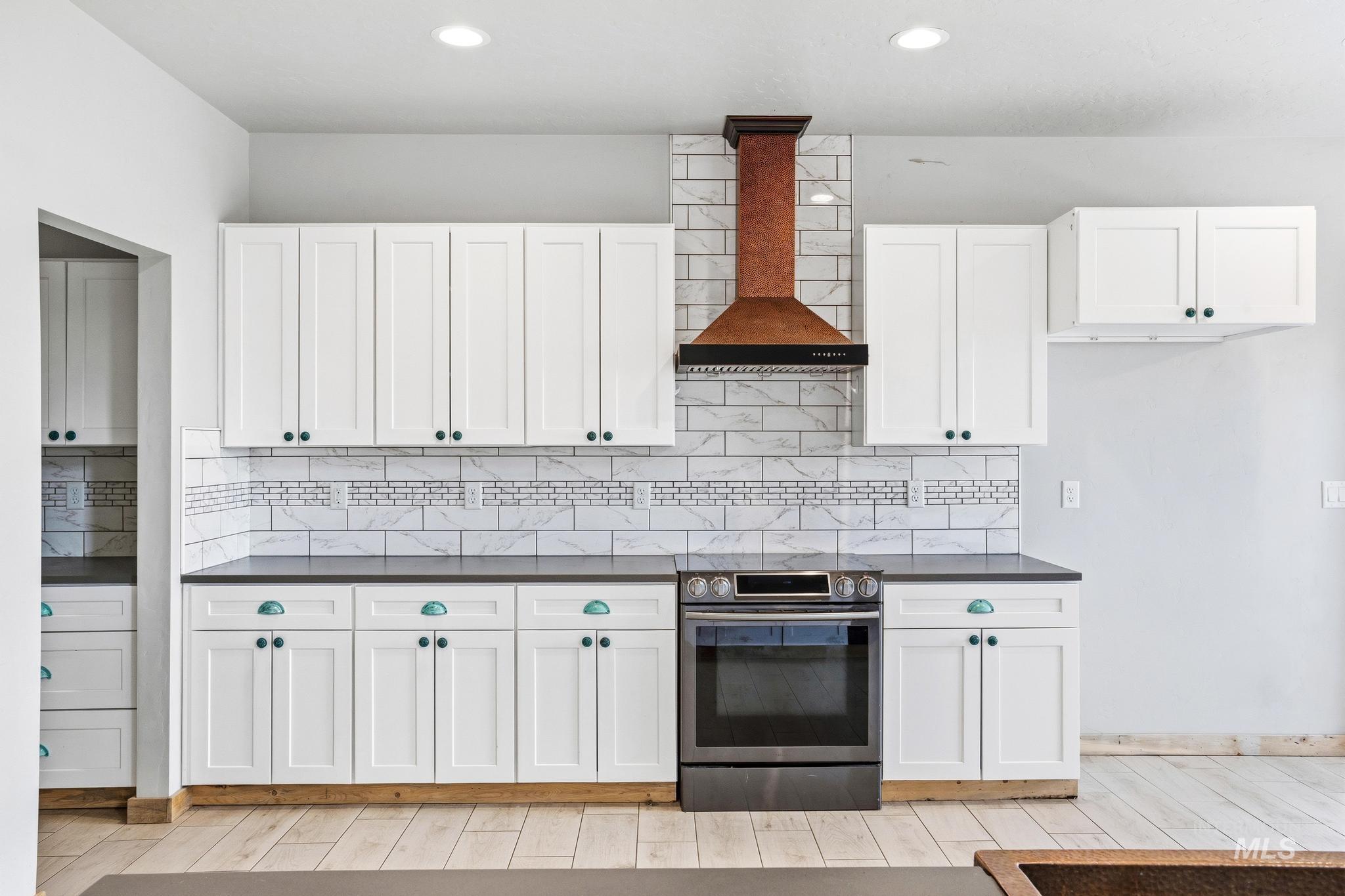 870 Desert Wind Road Boise, ID 83716 - Photo 7 of 50 Open-concept living area featuring wood-finish tile flooring, exposed timber beams, a copper farmhouse sink, and a stone-clad fireplace