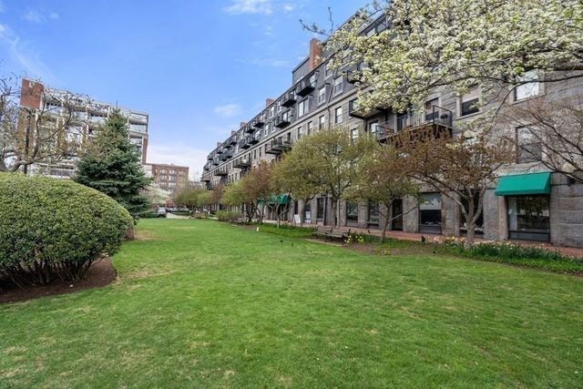 a view of a big building with a big yard and large trees