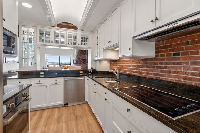 a kitchen with a stove and white cabinets