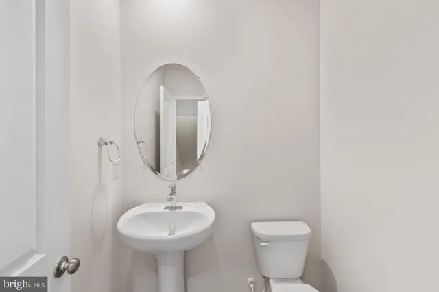 a bathroom with a toilet a sink and a mirror