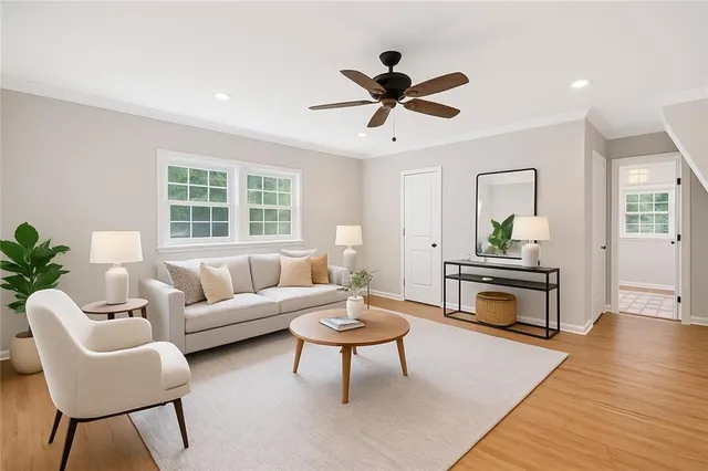 a living room with furniture a window and a wooden floor