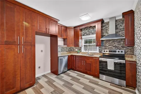 a kitchen with stainless steel appliances granite countertop a refrigerator and a stove top oven