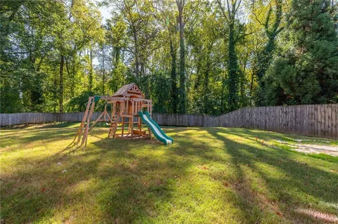 a view of swimming pool with a big yard and large trees