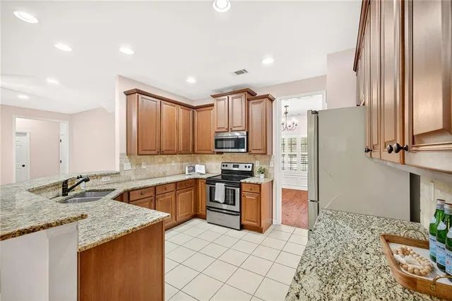 a kitchen with stainless steel appliances granite countertop a sink stove and refrigerator