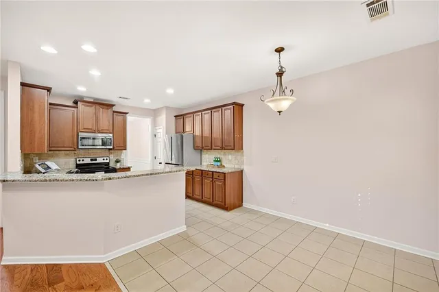 a kitchen with kitchen island granite countertop a stove top oven a sink a counter top space and cabinets