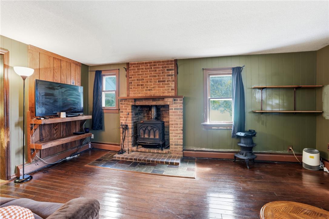 3573 Lower Saucon Road Hellertown, PA 18055 - Photo 5 of 56 Rich hardwood flooring complements a classic brick fireplace hearth flanked by wood-trimmed windows.