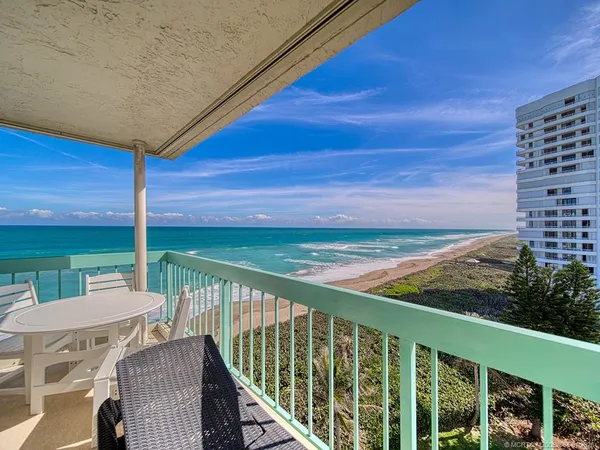a view of a chairs and table in the balcony