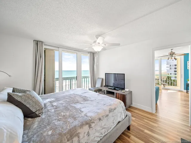 a bedroom with a large bed a flat tv screen and dresser